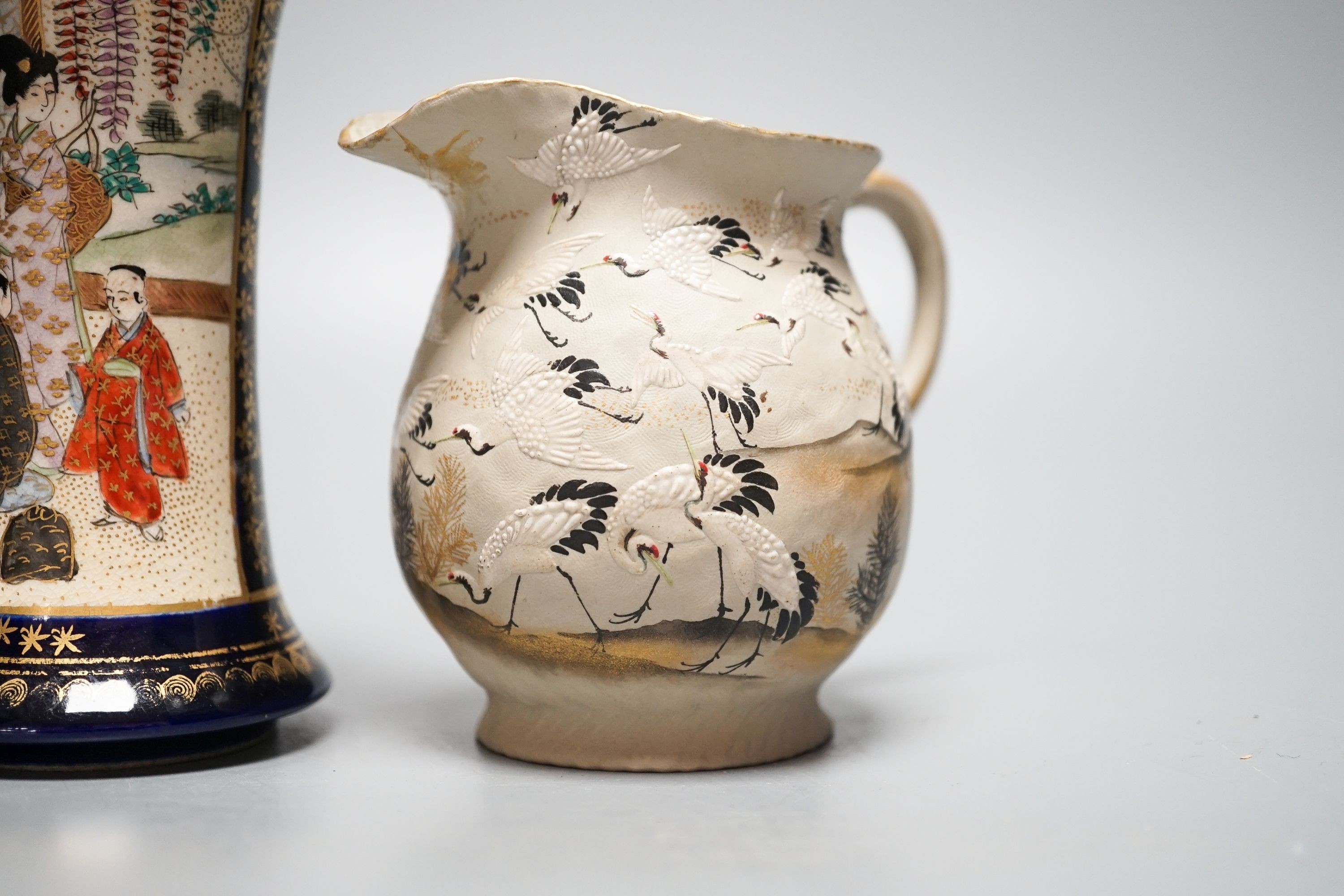 A Japanese black ground ‘cranes’ cloisonné enamel vase, 18.3cm, a Satsuma pottery vase and a crane decorated jug (3)